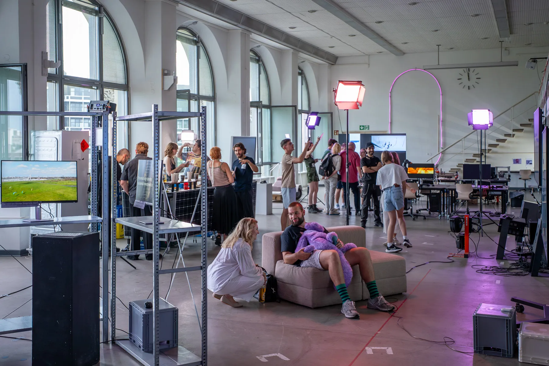 A public event in the Co-Lab, with visitors, installations, mobile furniture and presentation equipment distributed throughout the space.