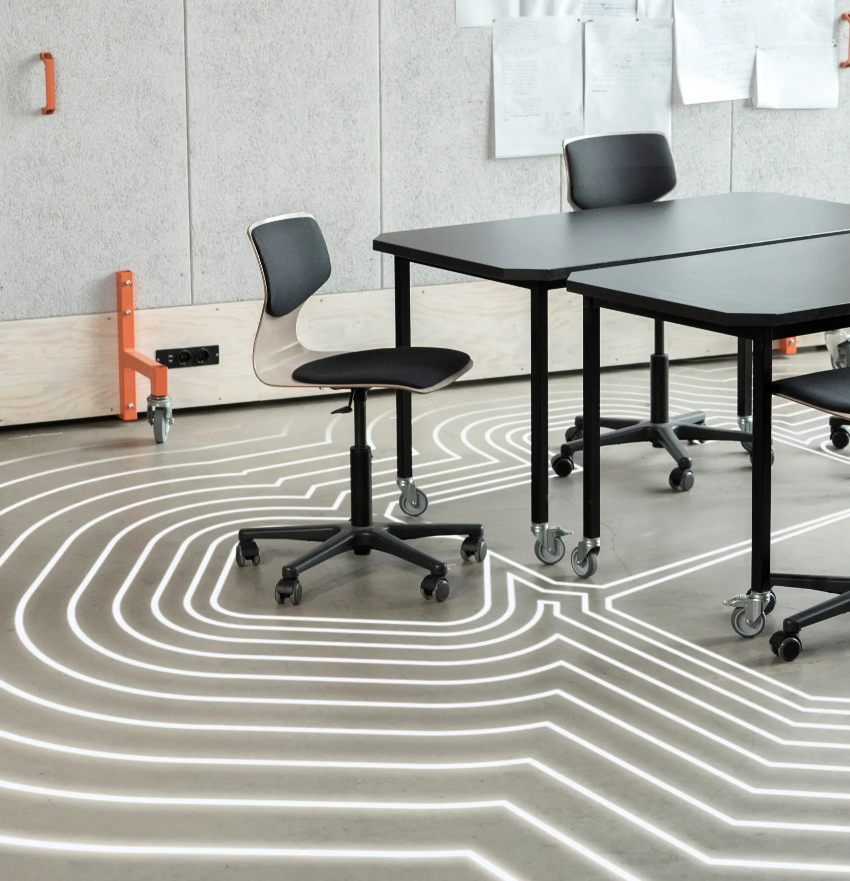 Mobile furniture stands within a projected pattern of concentric lines on the floor.